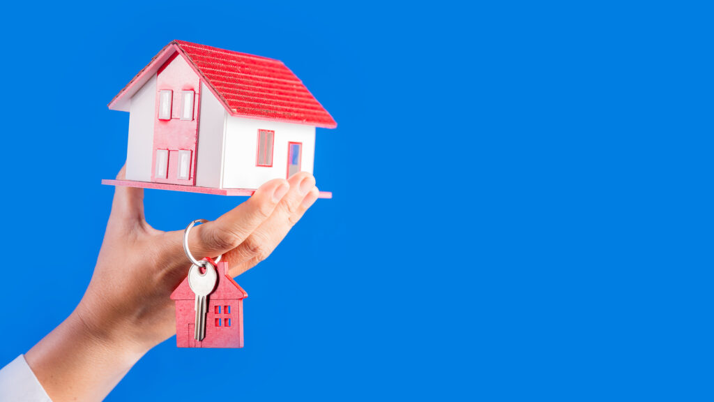 Hand holding toy house, keys